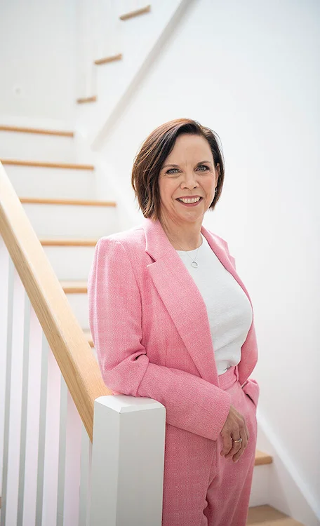 Marisa Yaksich standing on the stairs of a modern home.